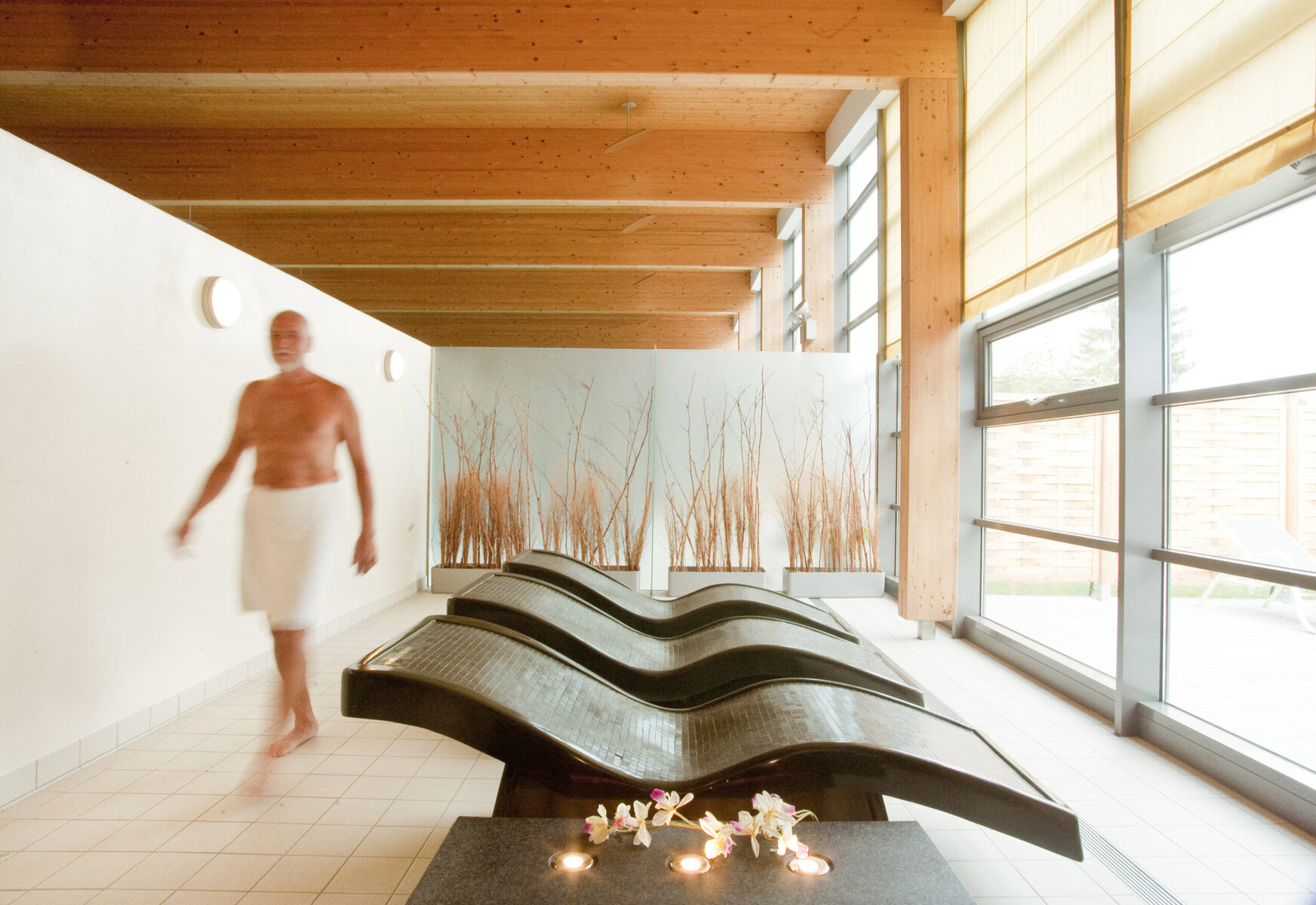 Ein abgetrennter Indoor Bereich um zu entspannen. Es gibt Liegen und einen Ausblick in den Garten.