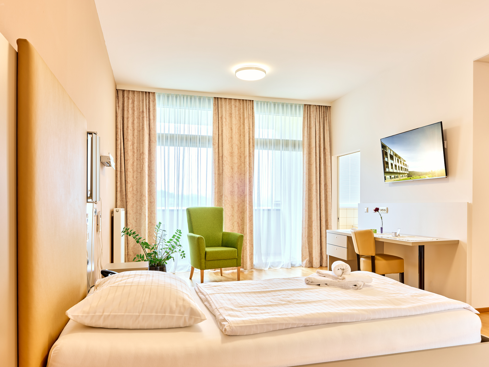 Ansicht eines Zimmers mit einem Doppelbett in der Privatklinik Hollenbrunn.